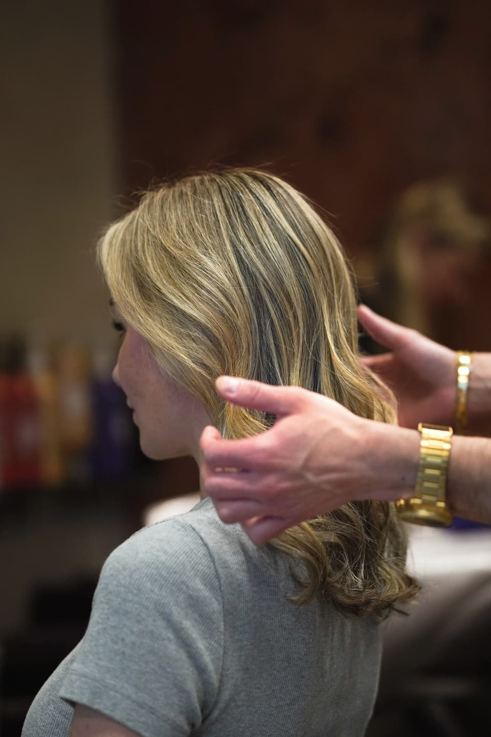 A stylist working product through the hair.